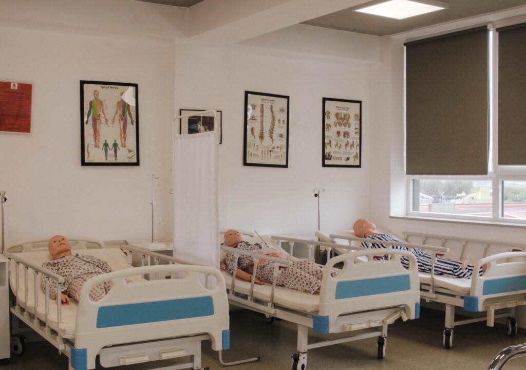 Durable medical training equipment including patient care manikins and hospital beds for university teaching environments