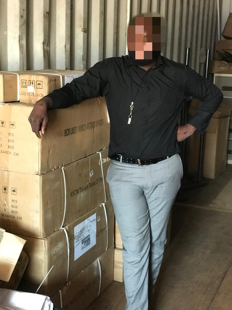 A staff member at Zambia Medical University leans confidently on delivered medical training equipment