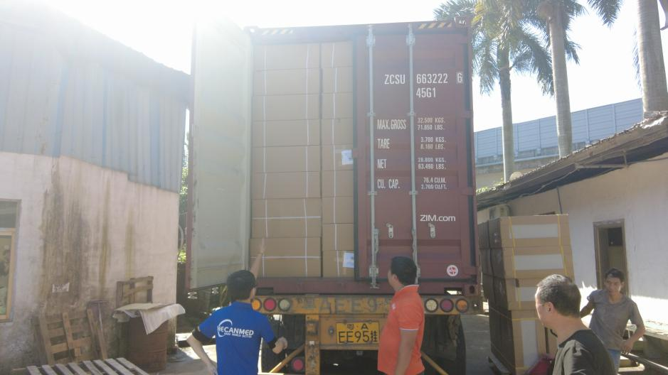 MeCanMed staff supervise bulk cargo loading into a shipping container at a reliable medical equipment factory in Guangzhou.