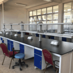 Clean, modern university medical laboratory room featuring integrated workbench stations and blue storage cabinets.